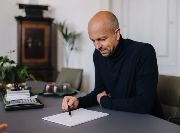 Steuerberater überprüft Unterlagen sorgfältig im Arbeitszimmer der Kanzlei