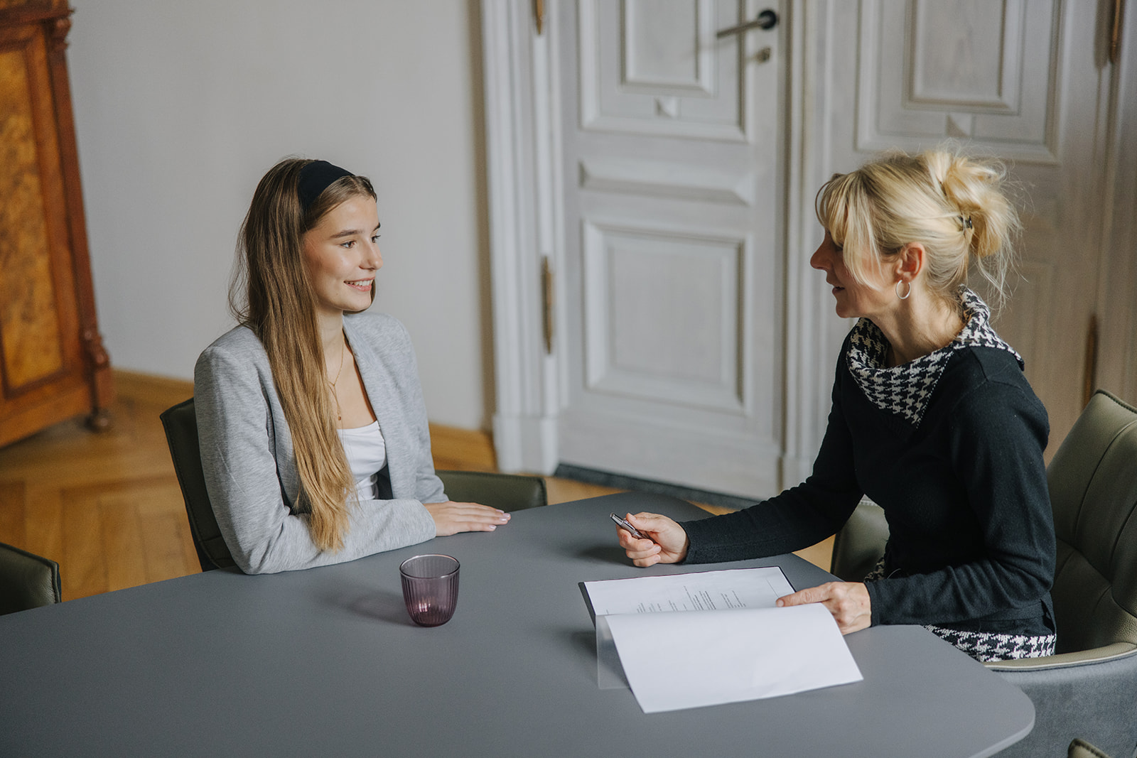 Zwei Mitarbeiterinnen der Kanzlei im persönlichen Gespräch am Besprechungstisch